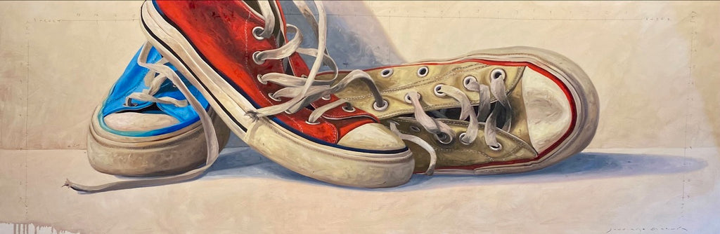 horizontal closeup of red, white, and blue converse lying together. 