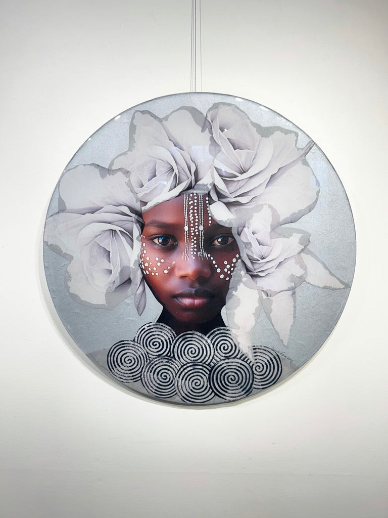 Young Black girl looking straight ahead adorned with a white flower crown, tribal markings, and a silver necklace.