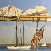 Sail and American flag in the foreground with beautiful sailboat in the background.