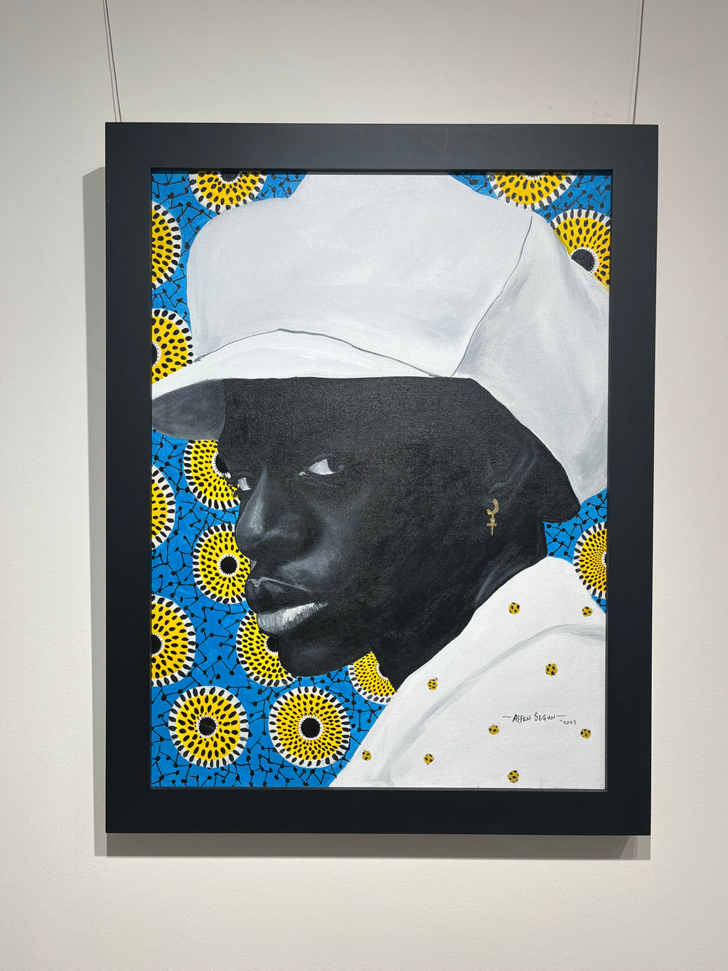 mixed media portrait of a black man with white hat and blue and yellow background, fabric, acrylic